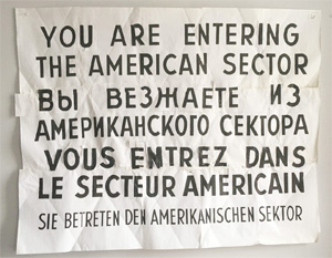 A collaged image that reads, "You
Are Entering the American Sector" in English, Russian, French and German.